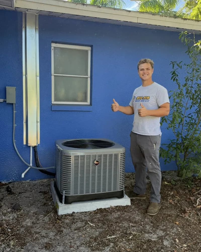 Big Air technician giving double thumbs up next to a new Ruud condenser installation in Fort Myers
