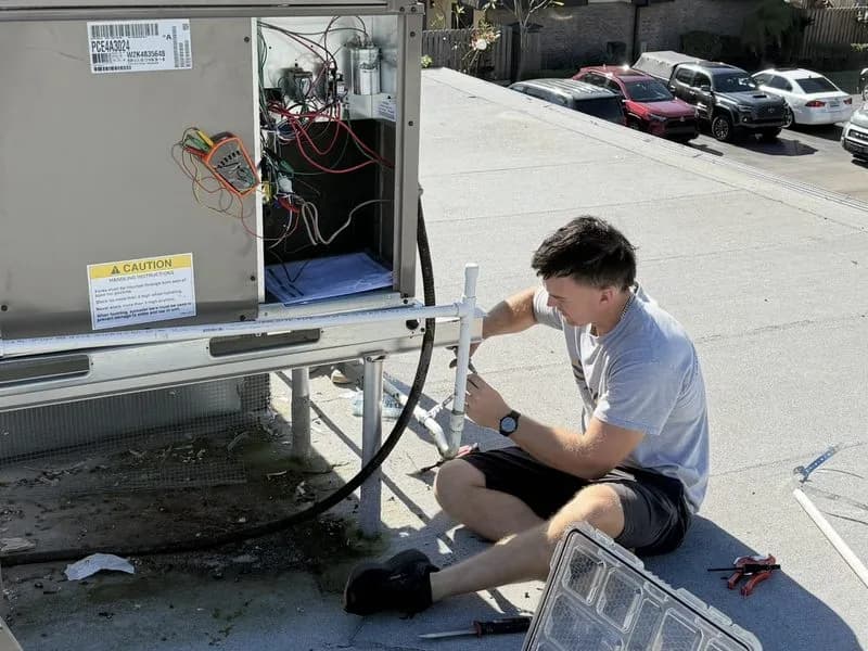 Big Air technician performing rooftop AC repair in Fort Myers Florida